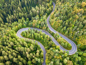 Winding road from high mountain pass, in summer time. aerial view by drone. romania