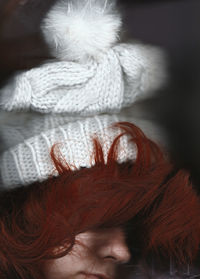 Close-up of young woman with redhead wearing knit hat