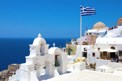 Panoramic view of sea and building against clear blue sky