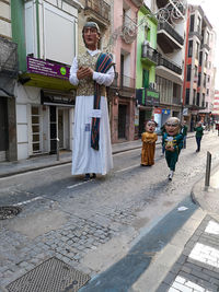 Portrait of people standing on street amidst buildings in city