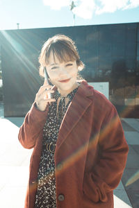 Portrait of young woman talking on phone outdoors