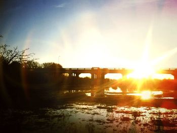 Bridge over river at sunset