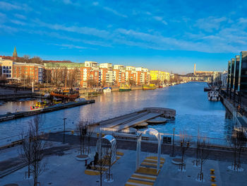 High angle view of illuminated buildings by river against sky