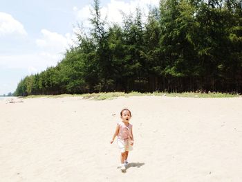 Full length of boy walking on sand at beach