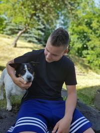 Man with dog sitting on plant