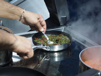 Cropped hands preparing food in kitchen