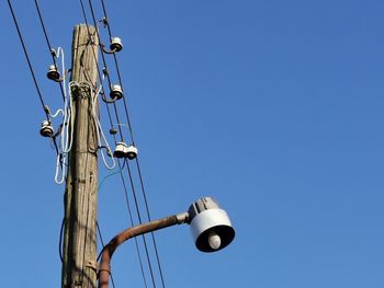 Low angle view of street light against clear blue sky