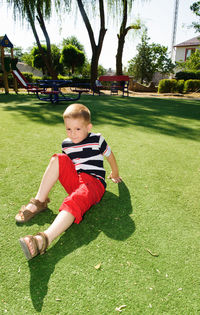 Full length of boy on grass against trees