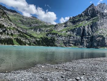 Scenic view of lake by mountains against sky