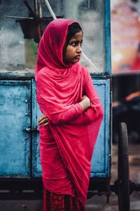 Young woman looking away while standing outdoors