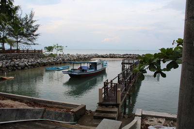 Boats moored in sea against sky