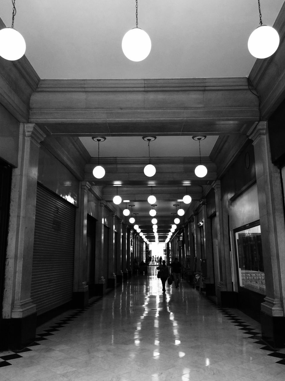 illuminated, lighting equipment, ceiling, indoors, architecture, built structure, the way forward, corridor, diminishing perspective, in a row, electric light, electric lamp, hanging, lamp, empty, night, street light, incidental people, vanishing point, lit