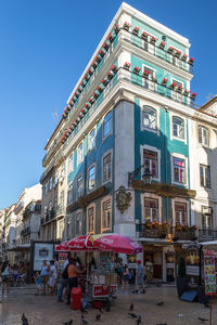 People on street against buildings in city