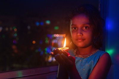 Portrait of girl holding illuminated lighting equipment