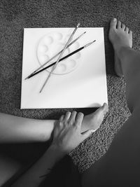 Cropped hand of woman writing in book