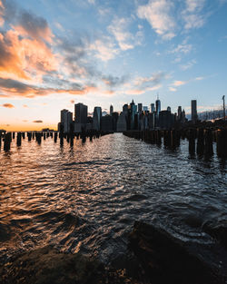 Scenic view of sea and buildings against sky during sunset