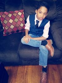 Boy sitting on sofa at home