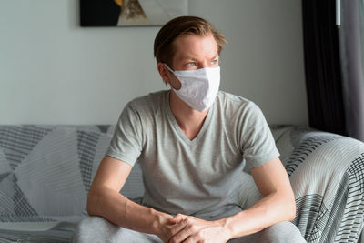 Midsection of man sitting on sofa at home