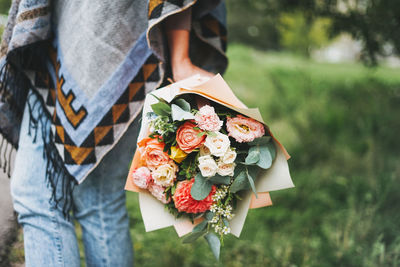 Midsection of woman holding rose bouquet