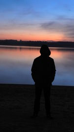 Rear view of silhouette man standing on beach