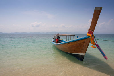 Boat moored on sea against sky