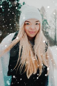 Portrait of smiling young woman in snow