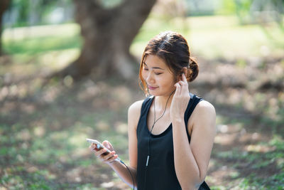 Young woman listening music on smart phone