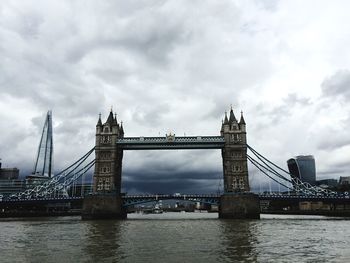 Golden gate bridge over river against cloudy sky