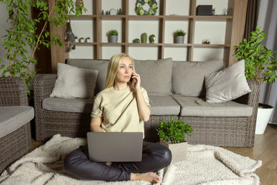 A woman talks on the phone at home working at home as a freelancer. distant working concept