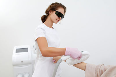 Young woman wearing sunglasses against white background