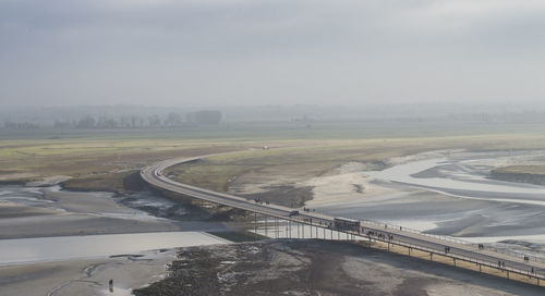 Road by river against sky