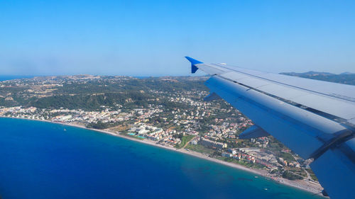 Aerial view of sea and cityscape against sky