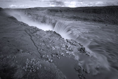 Scenic view of waterfall against sky