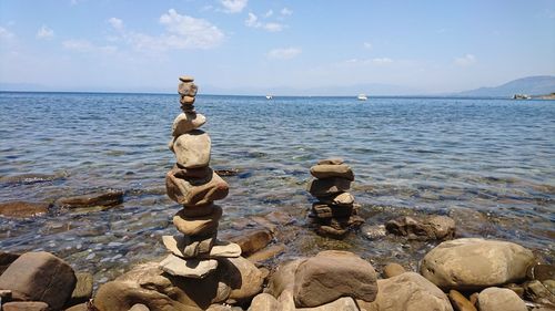 Stack of pebbles on beach against sky