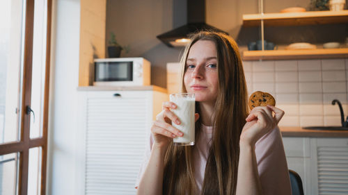 Portrait of young woman drinking beer glass