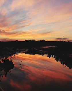 Scenic view of lake against orange sky