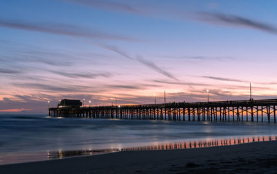 Pier over sea against sky during sunset