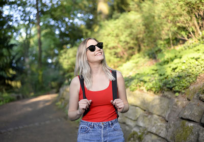 Smiling young woman wearing sunglasses while standing outdoors
