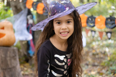 Halloween. portrait of cute arab girl in halloween costume and witch hat outdoor