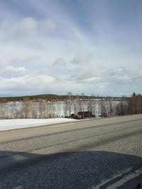 Scenic view of snow covered road against sky