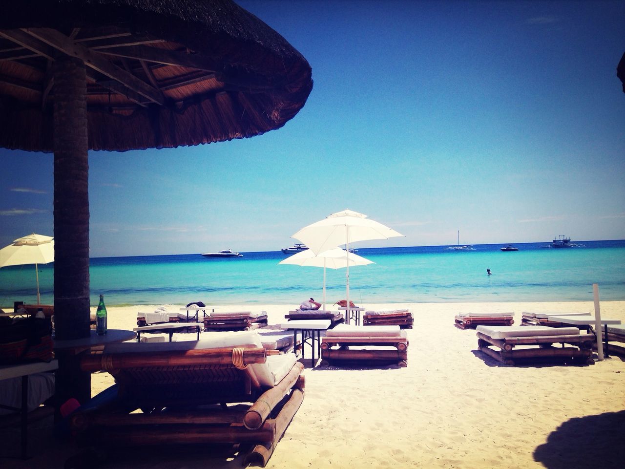 sea, beach, horizon over water, sand, water, shore, clear sky, tranquility, tranquil scene, blue, scenics, beach umbrella, vacations, beauty in nature, incidental people, nature, sky, parasol, lounge chair, sunlight