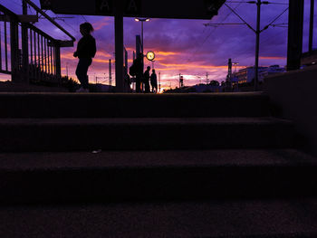Silhouette people standing on staircase against sky during sunset