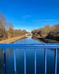 Scenic view of river against blue sky