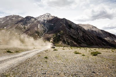 Road by mountain against sky