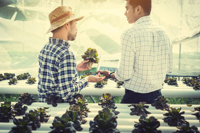 Supervisor discussing with farmer in greenhouse