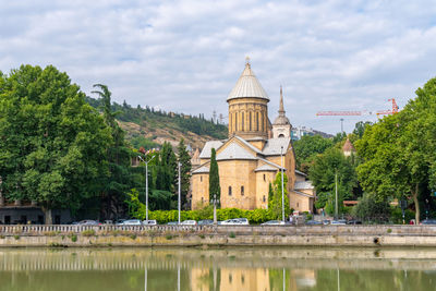 View of lake and buildings against sky