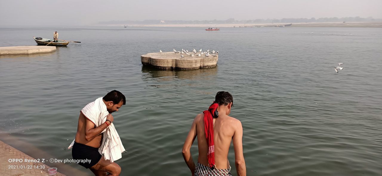 REAR VIEW OF FRIENDS ON SEA