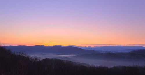 Scenic view of silhouette mountains against sky during sunset