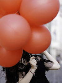 Midsection of holding red balloons