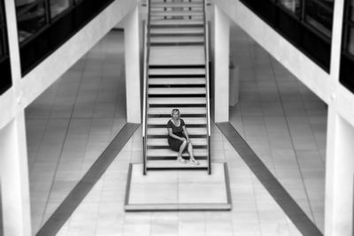 High angle view of woman sitting on staircase